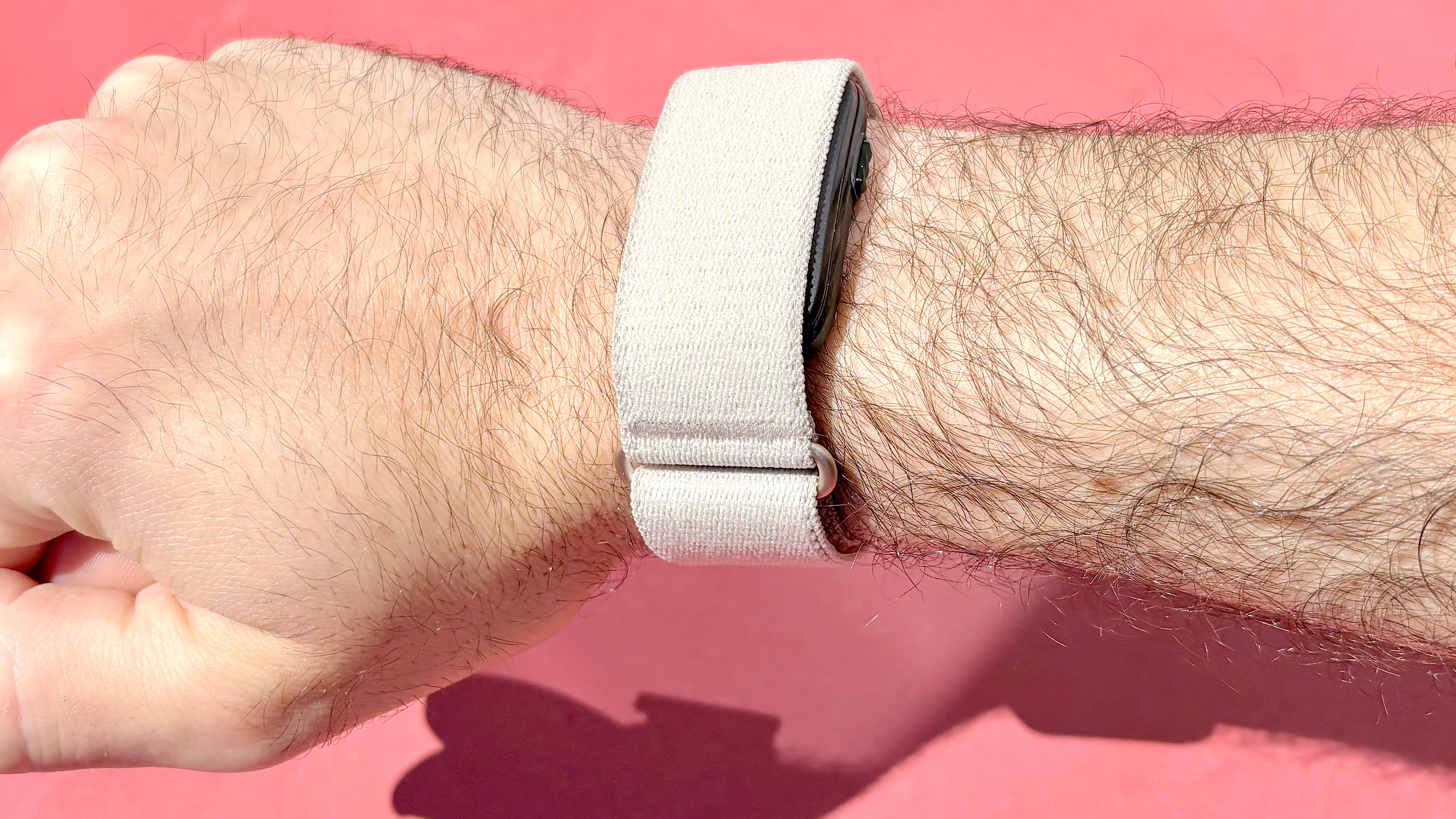 Close-up of the Garmin Cirqa on the writer's wrist against a red background