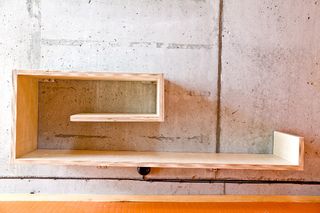 Stokkoya Resort by Svenning and Langklopp, Norway. A wooden shelf on a wall with a square spiraled design.