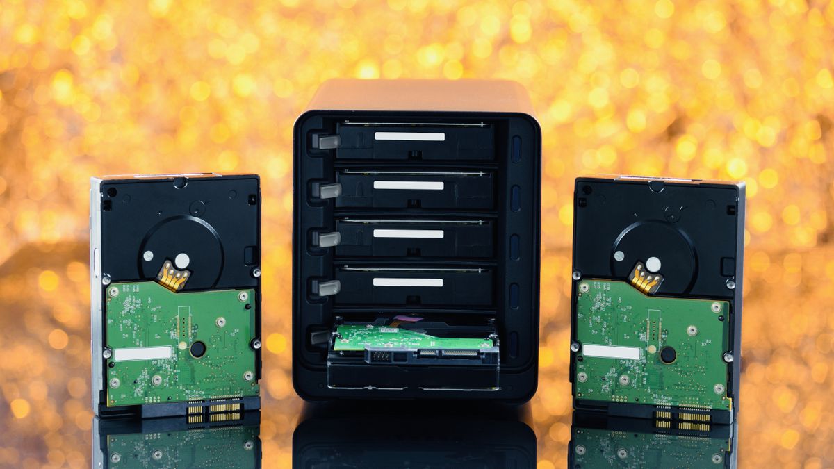 A NAS drive and hard disks against a yellow background