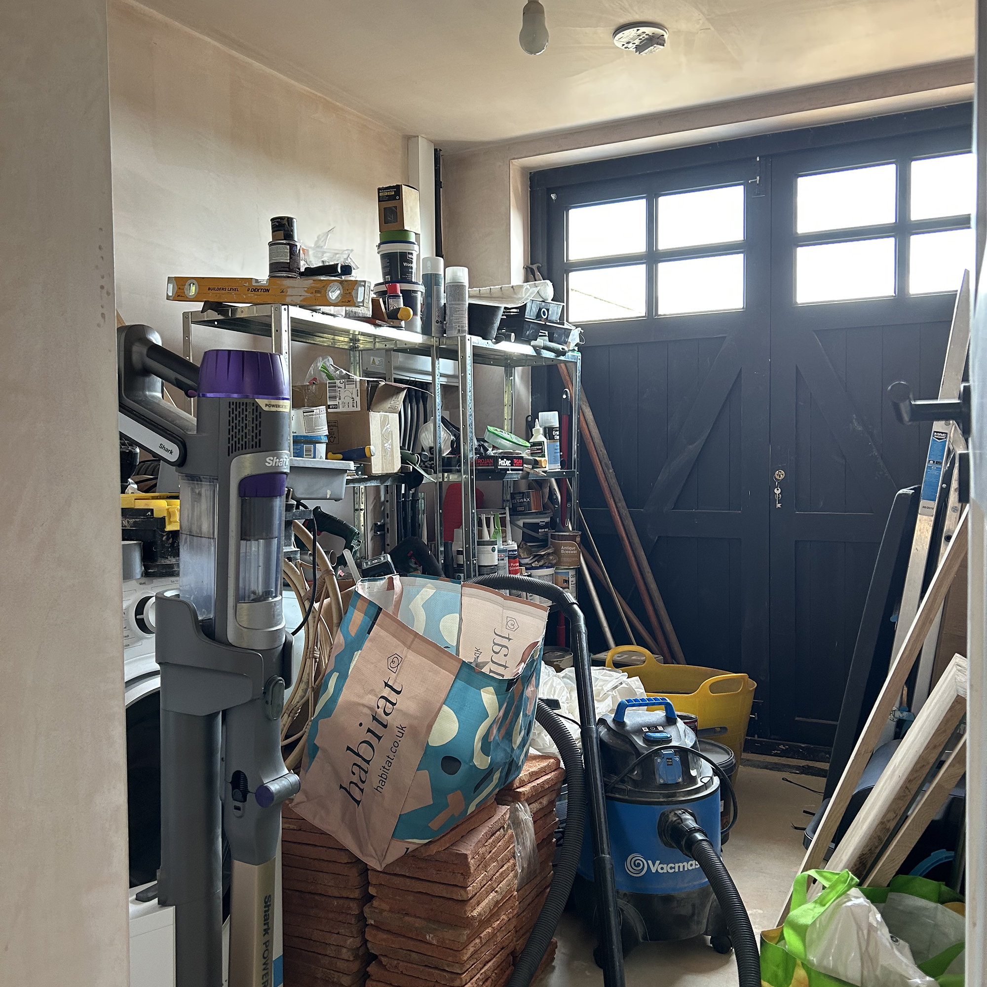 Cluttered garage with messy storage and piles of junk
