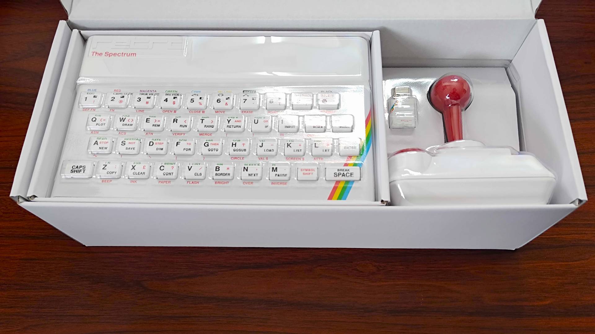 The Spectrum White Edition box with open lid revealing system, joystick, and USB Microdrive.