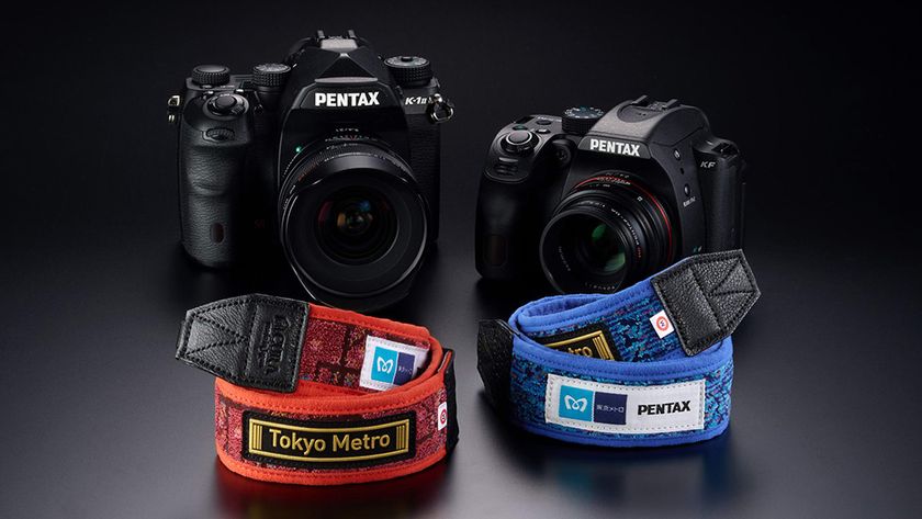 Ricoh Tokyo x Pentax Camera Straps (red and blue) in front of Pentax SLR cameras on a grey to black background 