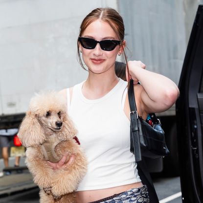 Lola Tung styled a scarf as a belt with a black leather Coach bag in NYC