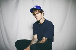 Justin Bieber sitting with baseball cap for AMAs press