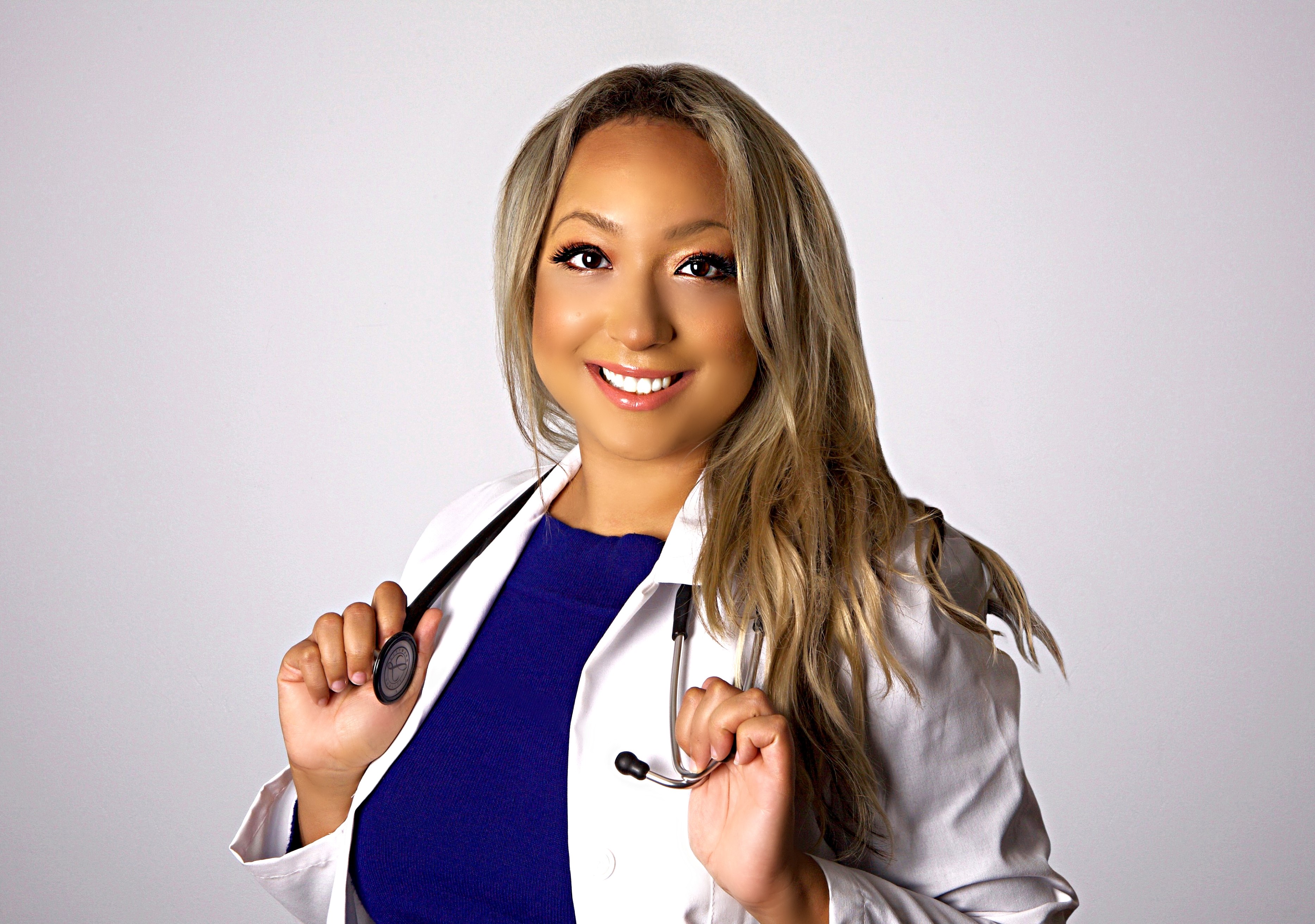an asian woman with blonde hair in navy scrubs and a white lab coat