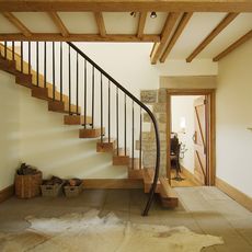 room with wooden staircase beam and white wall