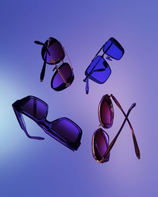 Range of Akoni eyewear suspended in the air, background of merged shades of blue and purple