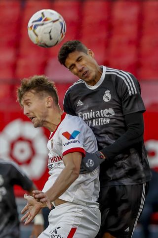 Real Madrid defender Raphael Varane challenges Sevilla's Luuk de Jong
