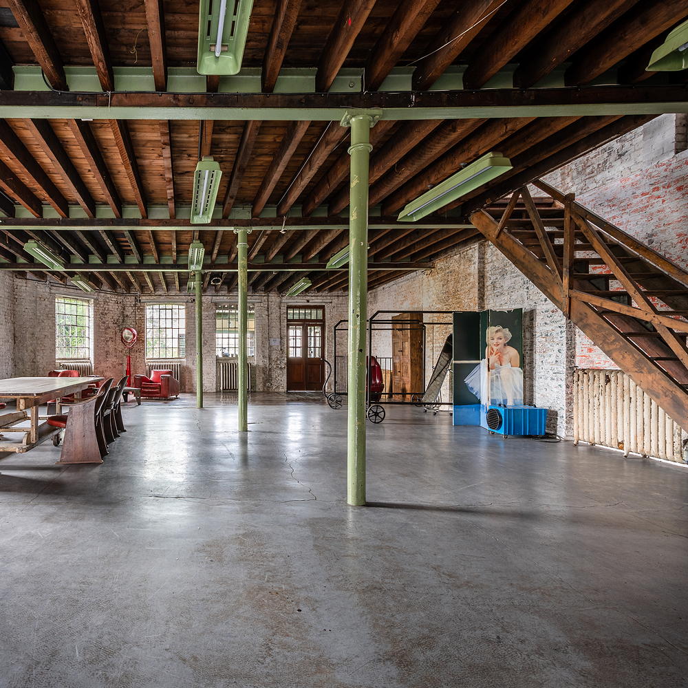 concrete floor with bricked wall and wooden stair case