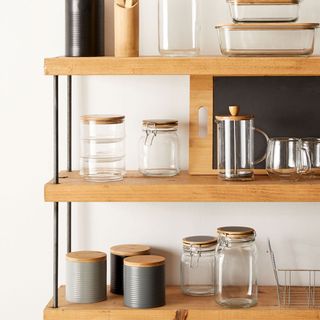 Wooden shelves with bin and white wall
