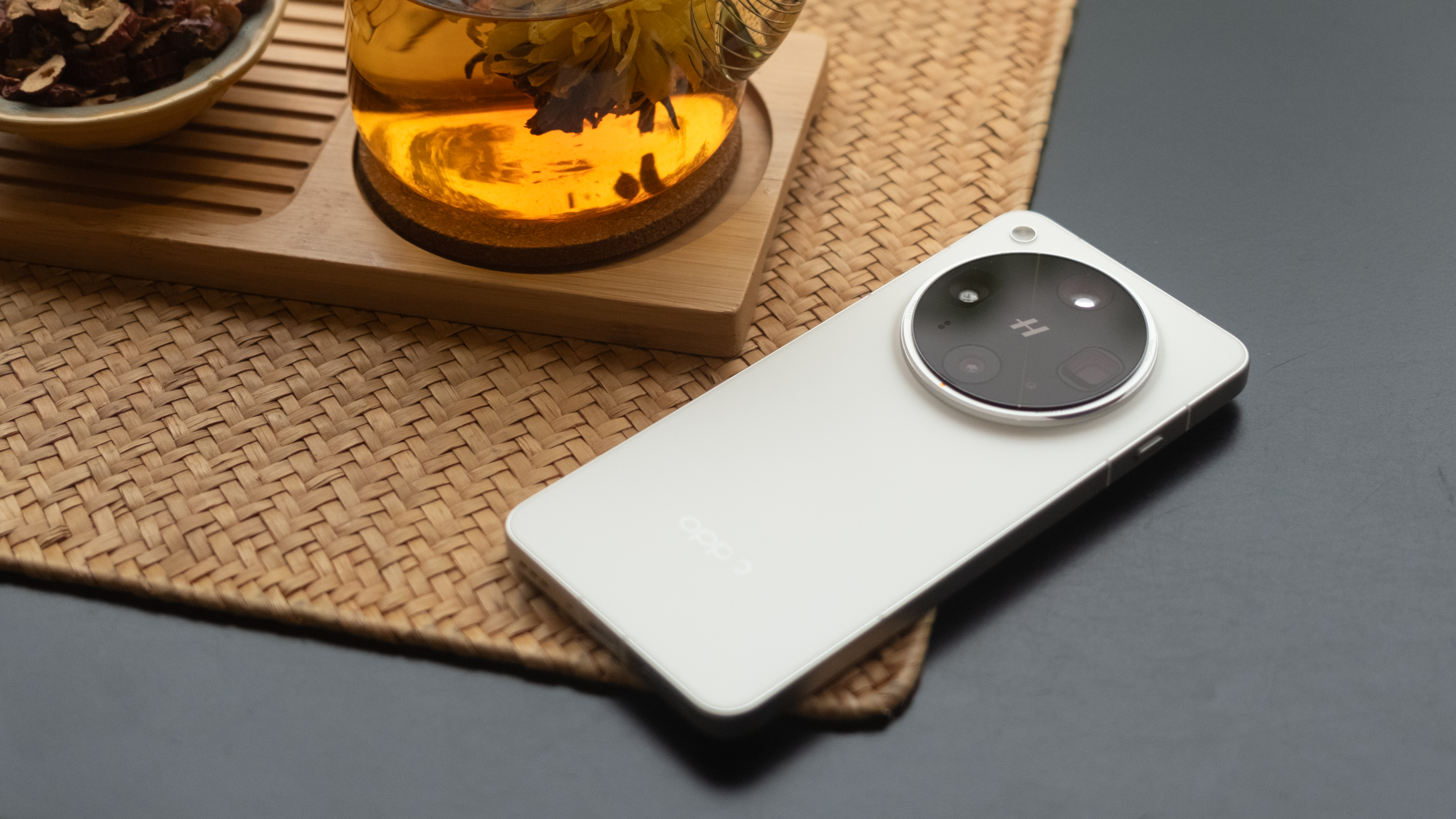 Oppo Find X8 Ultra phone on a wicker mat over a black table