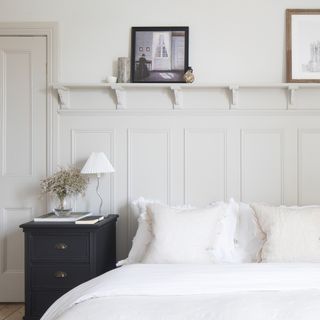 White bedroom with wall panelling and open shelving