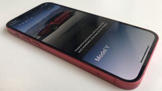 A picture of an Apple iPhone 12 with the Tesla app open
