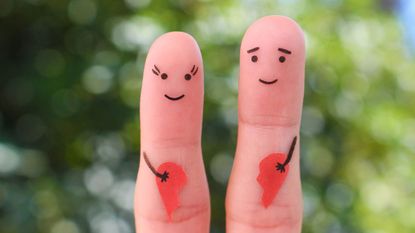 Two fingers with happy faces drawn on them.