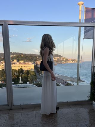 Eliza Huber wearing a white Zara dress with a brown Bottega Veneta bag at a restaurant in Nice.