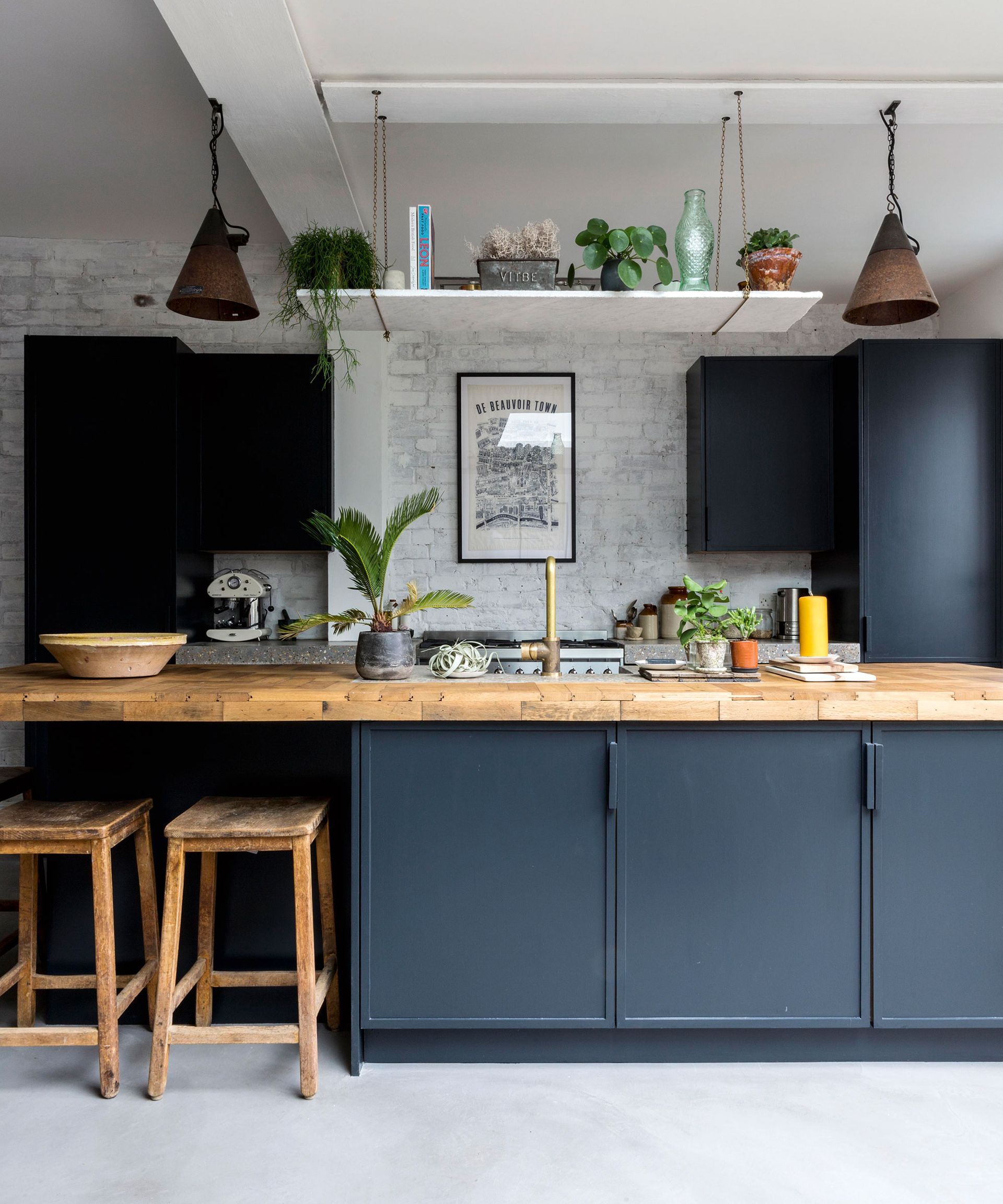 Sustainable kitchen with blue island, white brick wall and wood worksurface