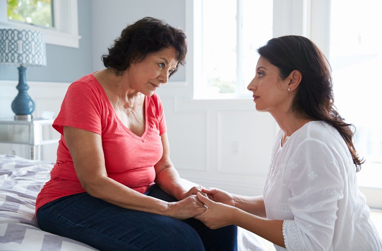 Adult Daughter Comforting Mother Suffering With Dementia