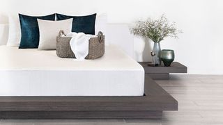 Best mattress protectors: The white Brooklyn Bedding Cooling Mattress Protector used on a mattress that's placed on a stylish dark wood bed frame