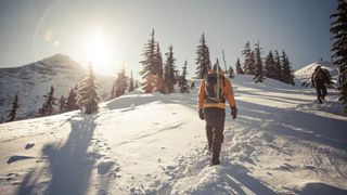 两个徒步旅行者方法峰会在雪地里