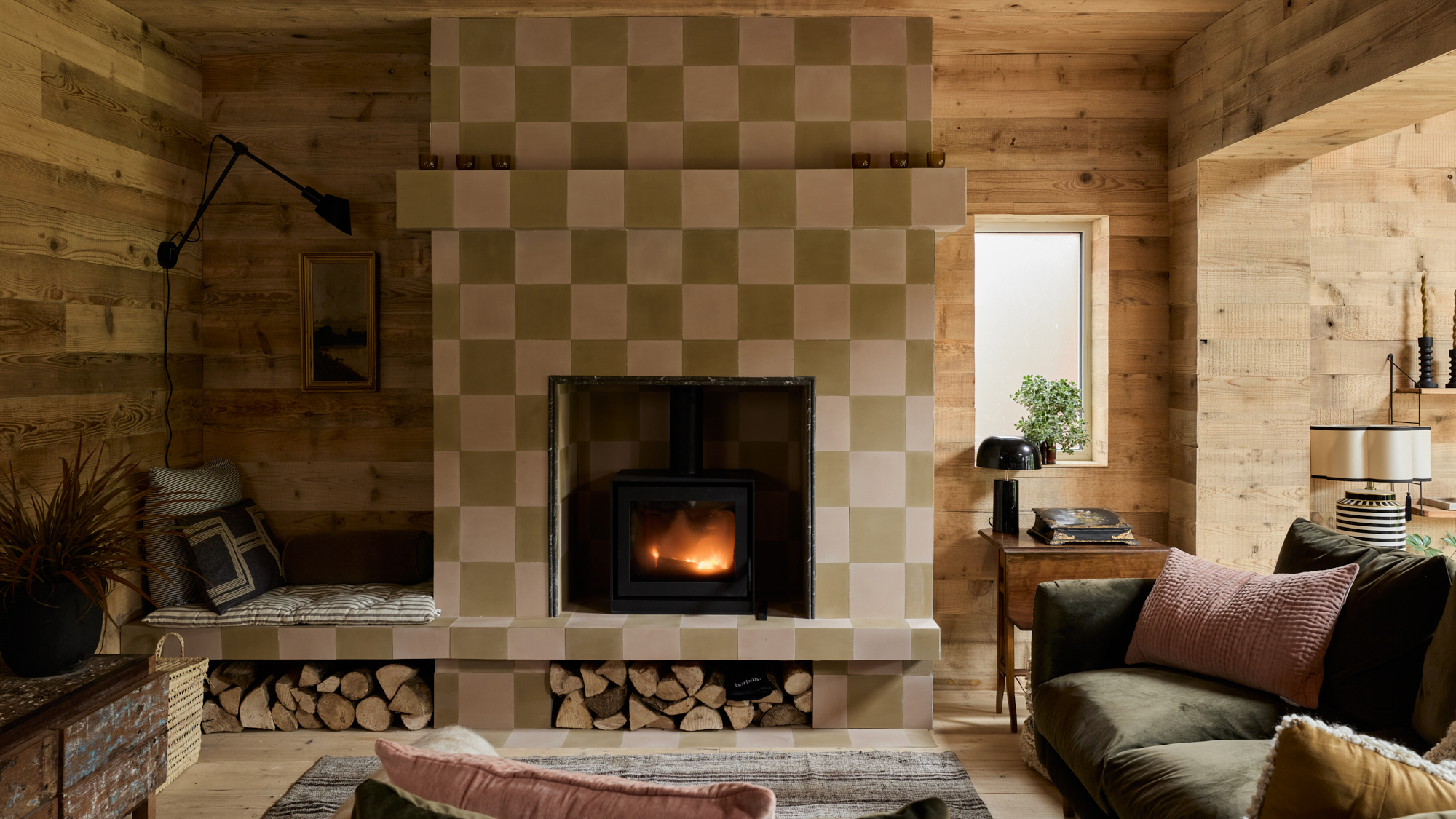 pink and green tiled fire surround with log storage and internal timber cladding