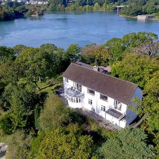 top view of house with green tree and clear blue water