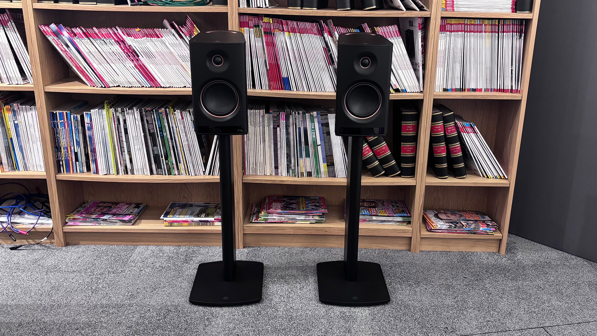 Yamaha NX-70A all-in-one system on stands in front of bookcase