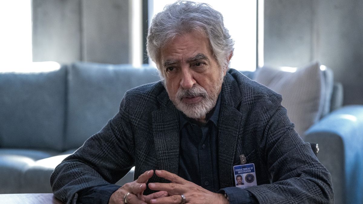 Joe Mantegna as David Rossi sitting at a table in Criminal Minds: Evolution 