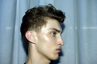 profile shot of male model with light hair that has been styled