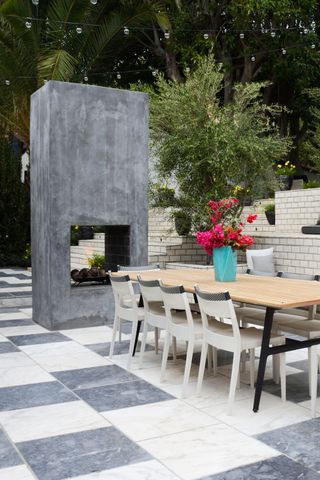 tiled outdoor dining area with statement freestanding fireplace