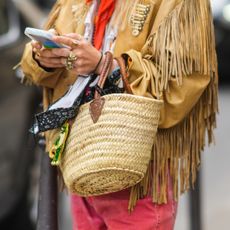 Edward Berthelot/Getty Images: woman holds a basket bag