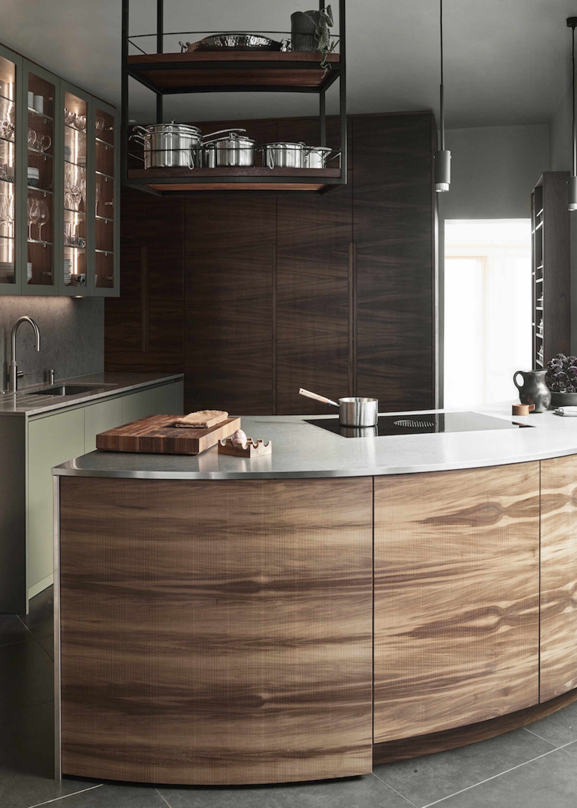 a sleek wooden kitchen island with an open shelf hanging above.