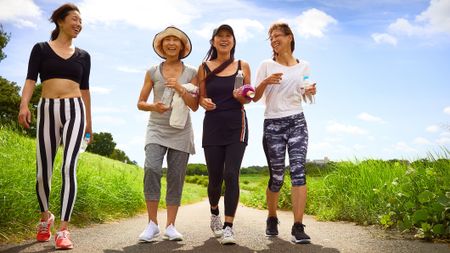 A group of women in athleisure wear take a walk in the countryside