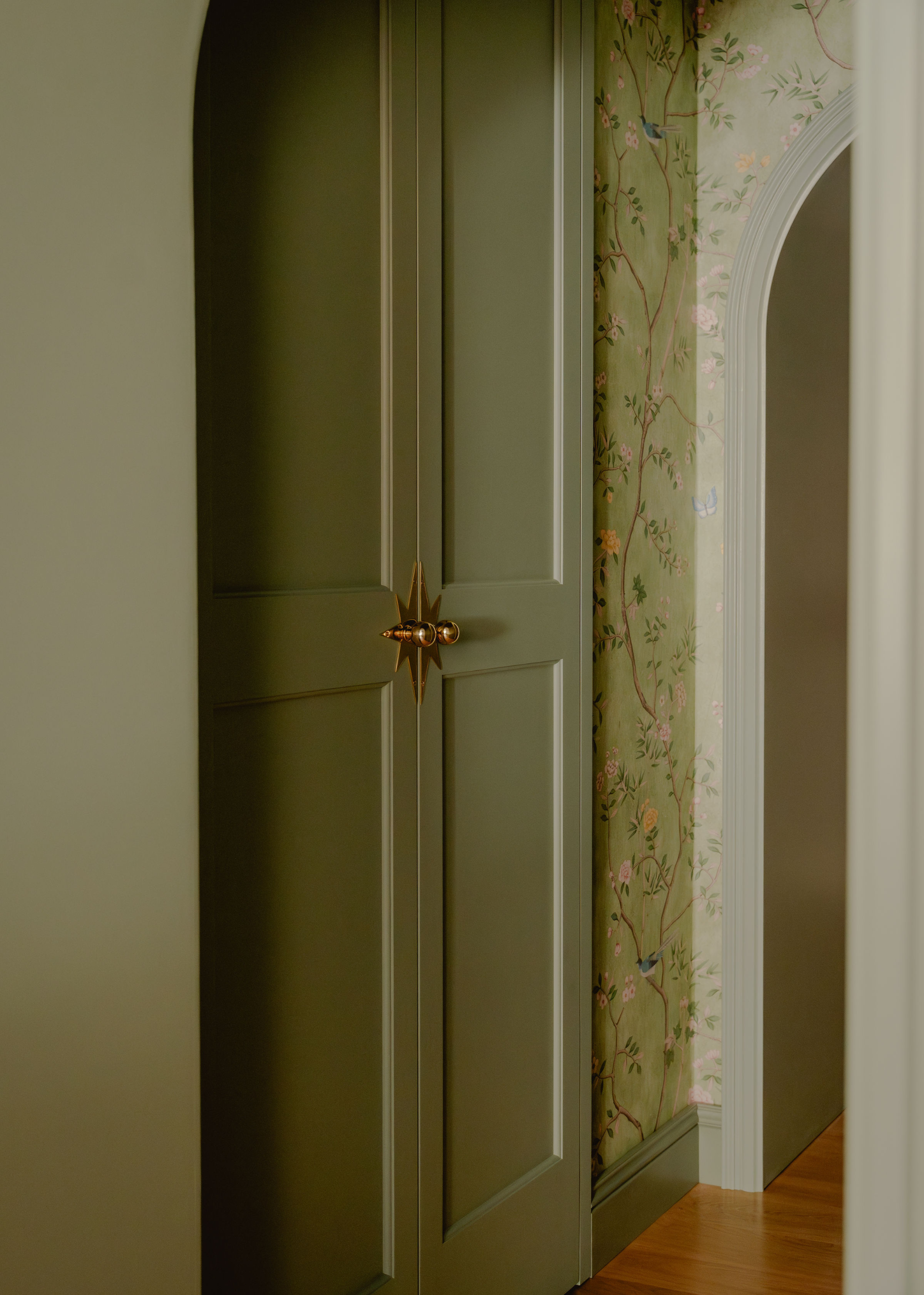 sage green hallways with floral wallpaper and arched doorways