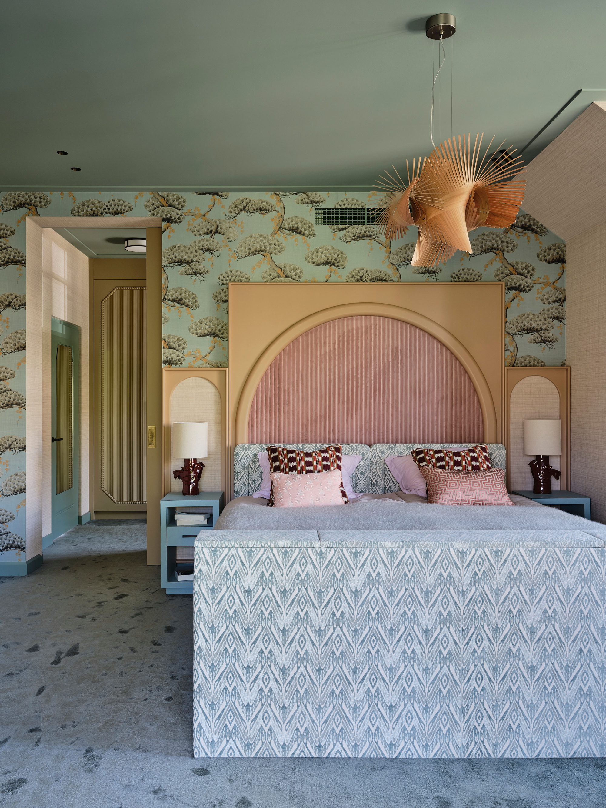 Bedroom with mint wallpaper and painted ceiling, blue carpet, blue bed with extended pink headboard