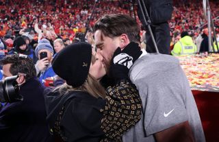 Taylor Swift and Travis Kelce kissing on the field after the 2025 AFC Championships game