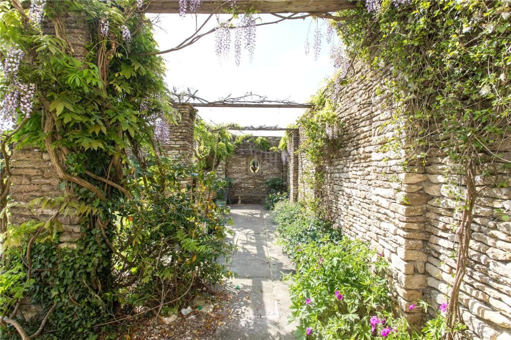 A garden court yard area with roses and other climbers in the garden