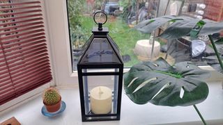 Solar lantern on a windowsill next to plant