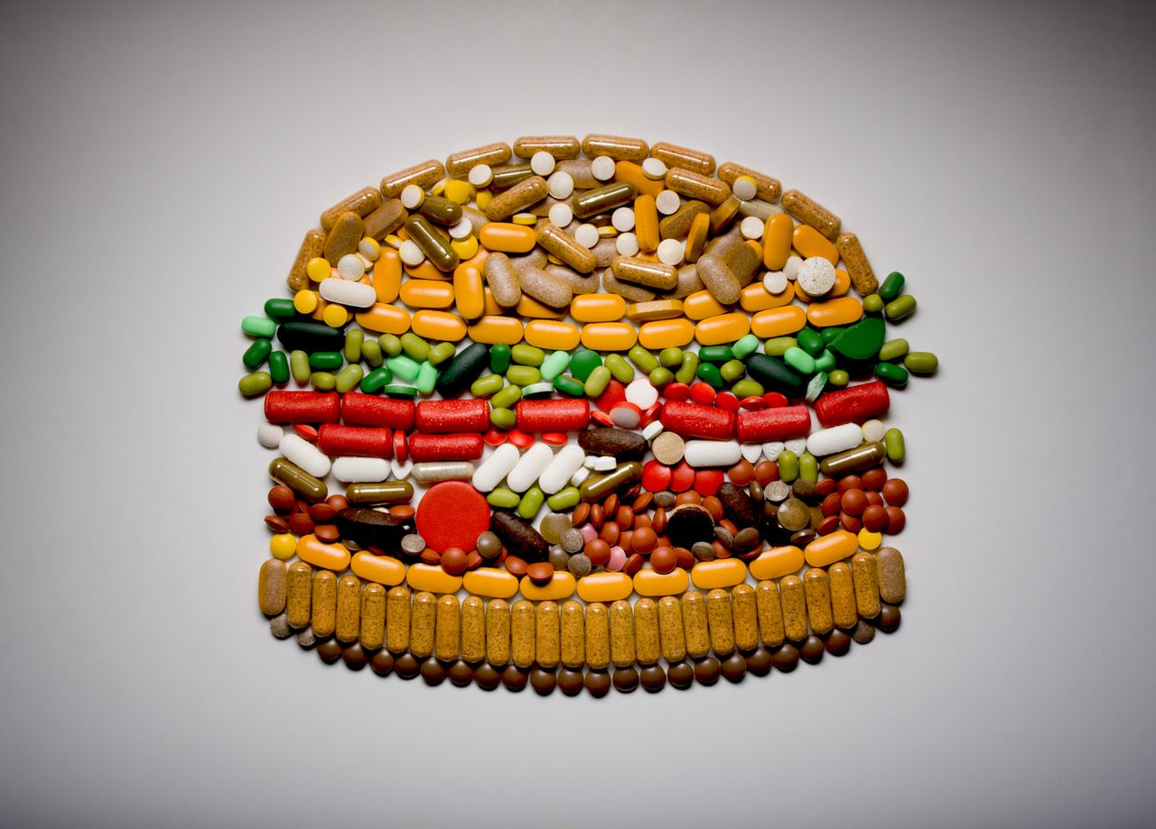 Capsules and pills in shape of hamburger, weight-loss drugs concept