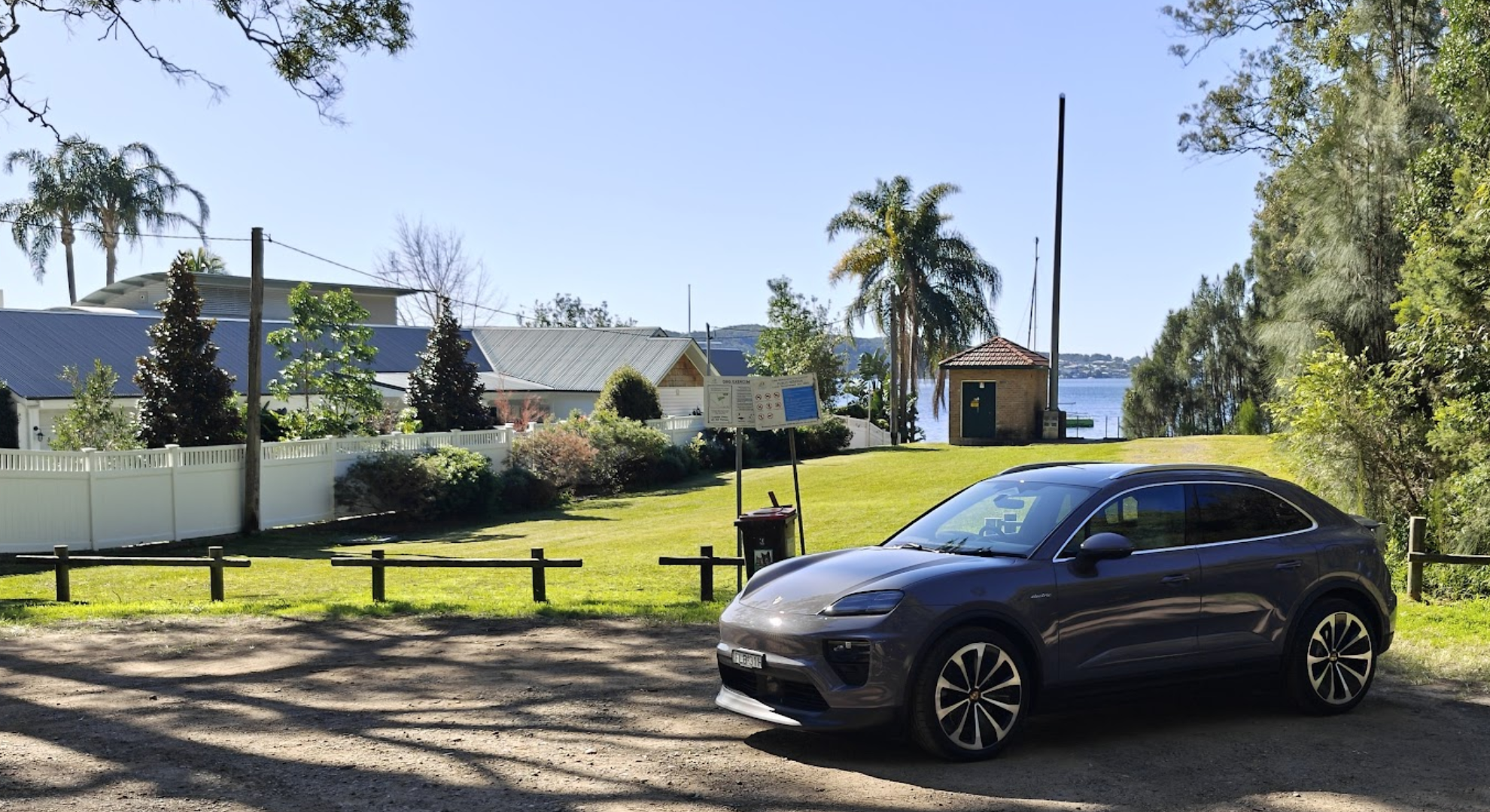 A Porsche Macan EV parked in front of a park