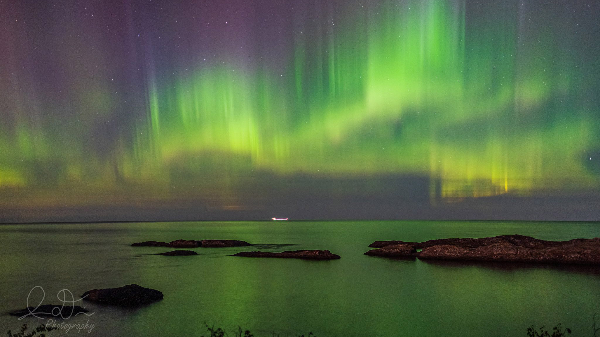 Aurora borealis glowing above a the sea in Upper Michigan.