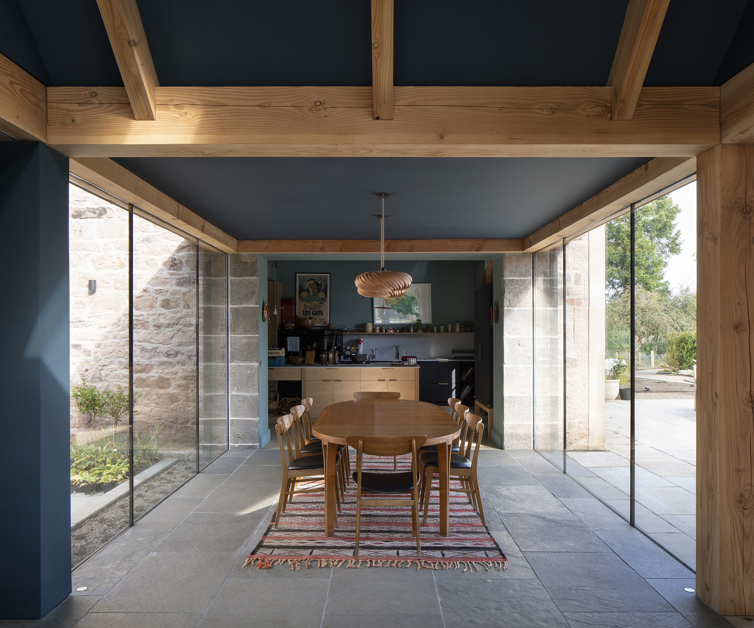 A dining room/kitchen with floor to ceiling glazing