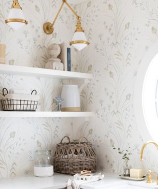 corner of utility room with light floral wallpaper, shelves and gold and white wall lights
