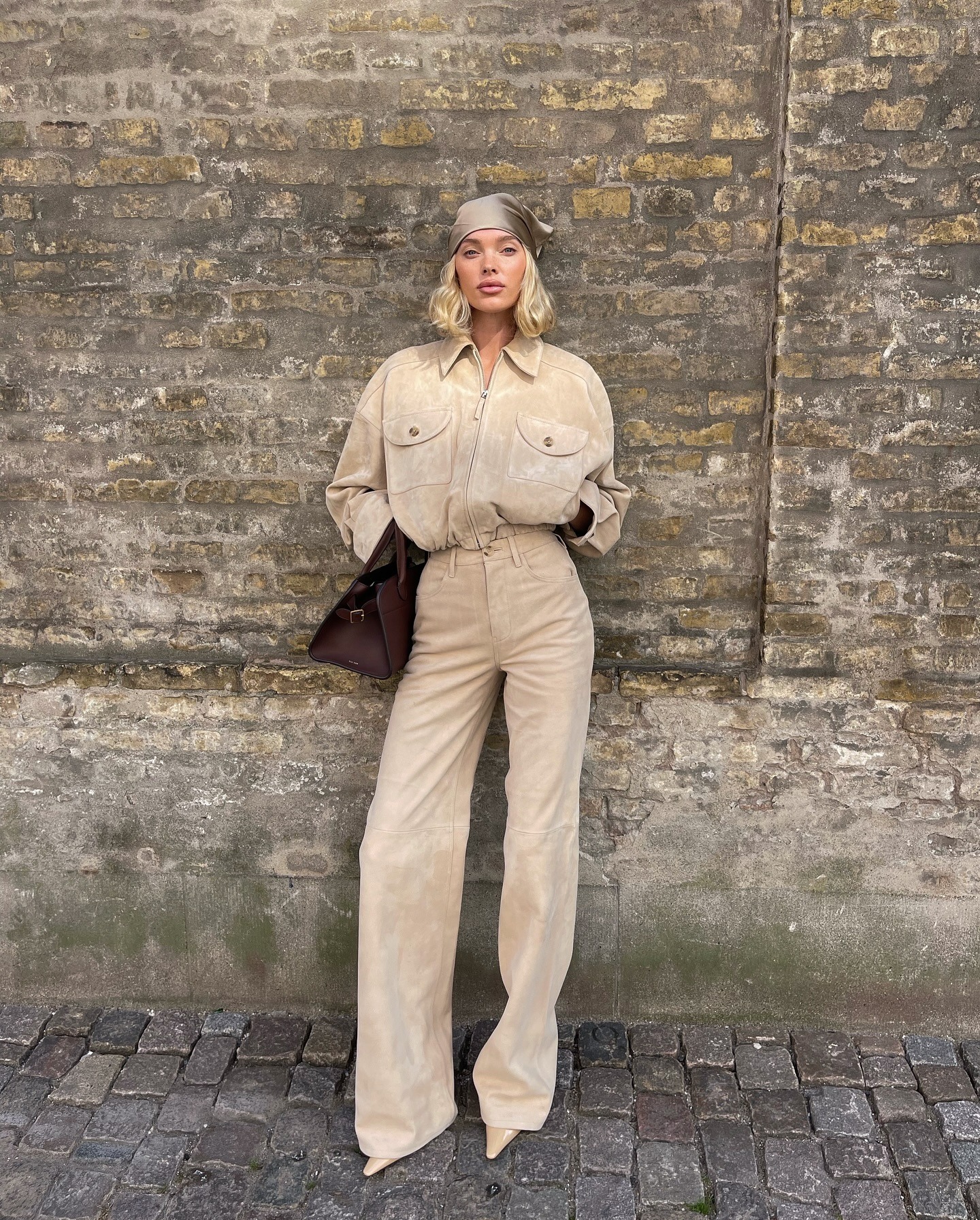 Elsa Hosk wearing a matching tan suede set with pointed-toe tan boots.