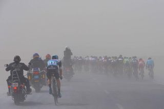 The peloton is buffeted by a sand storm on stage 2