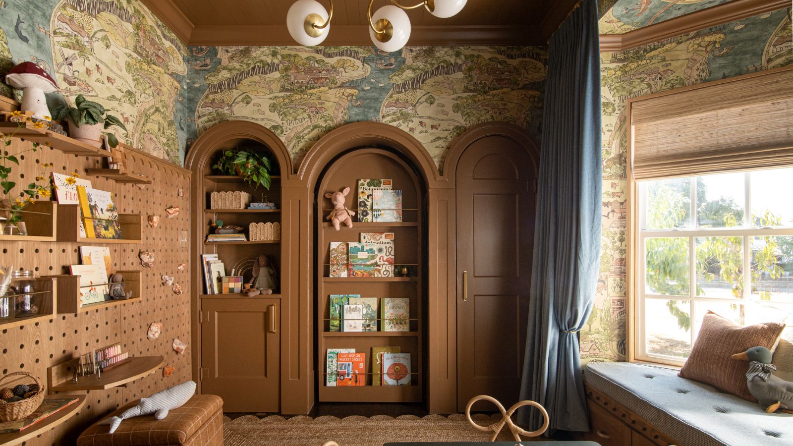 Nursery with curved cabinets and hidden door, bookshelves, map wallpaper, window seat and pendant light