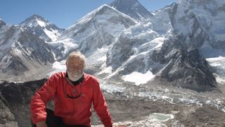 Chris Bonington sitting in front of some mountains