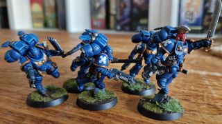 A group of painted Ultramarines on a wooden table
