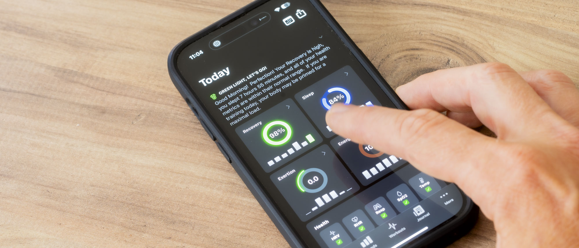A close up of a finger touching the homescreen of the Athlytic app on an Apple Iphone 14