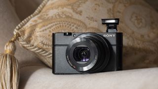 Sony Cybershot RX100 point-and-shoot camera on the arm of a sofa