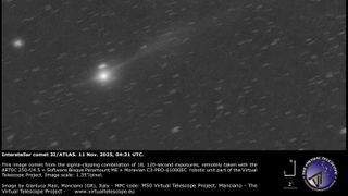 a grayscale image showing a white dot of 3I/ATLAS with a long white tail behind it.